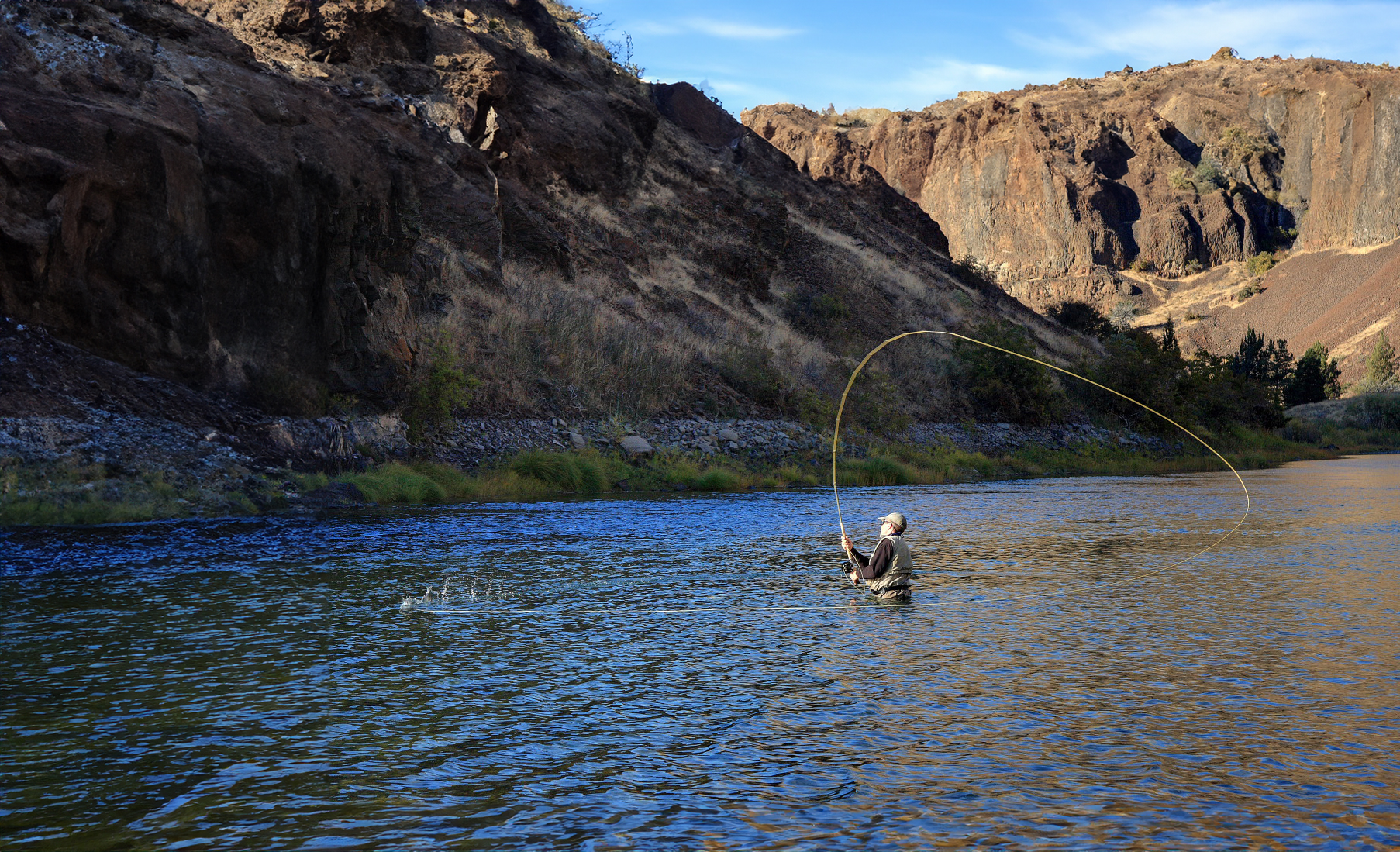 Angler spey casting in canyon river